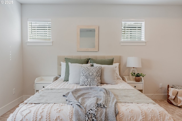 bedroom featuring baseboards and multiple windows