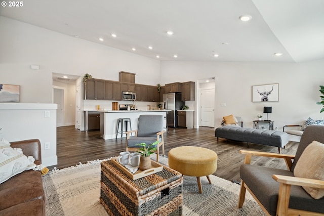 living area with dark wood-style flooring, recessed lighting, and high vaulted ceiling