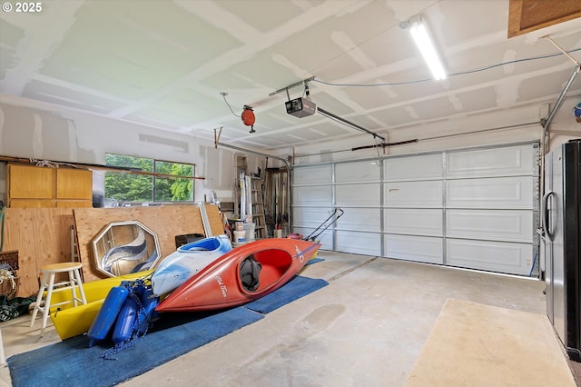 3621 NE 10th St, Otis, OR 97368 - garage featuring a garage door opener and freestanding refrigerator