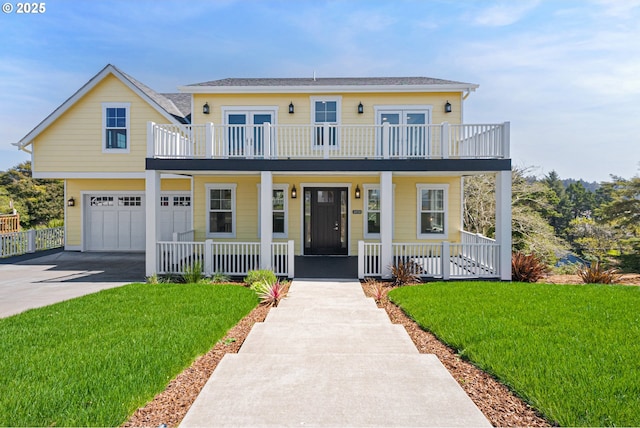 view of front of house with a front yard, covered porch, concrete driveway, and a balcony