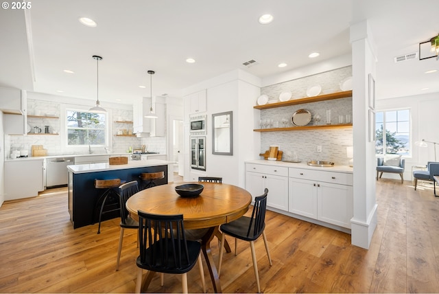 dining space with recessed lighting, visible vents, and light wood-type flooring