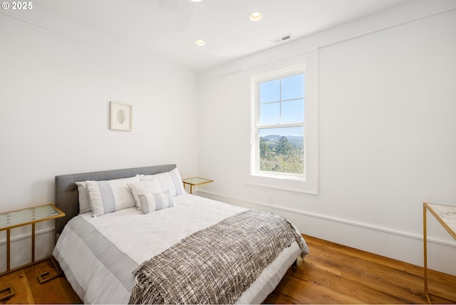 bedroom with wood finished floors, visible vents, and recessed lighting