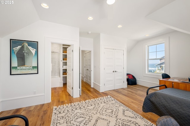 bedroom with vaulted ceiling, a closet, wood finished floors, and recessed lighting