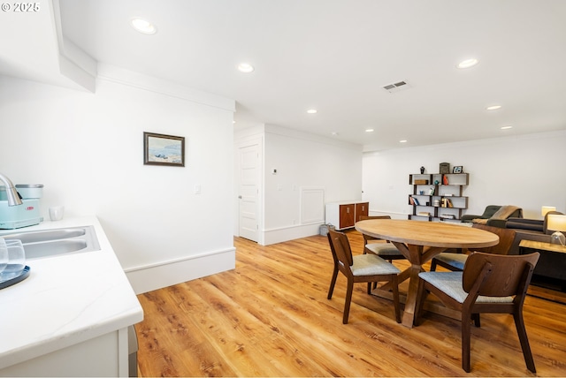 dining room featuring baseboards, visible vents, recessed lighting, light wood-style floors, and ornamental molding