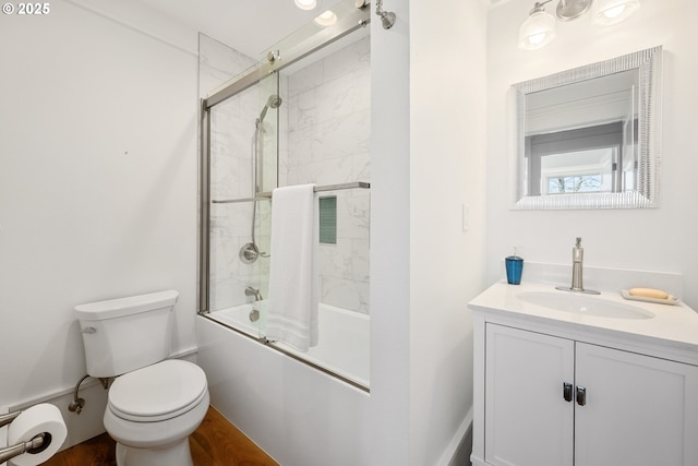 bathroom with enclosed tub / shower combo, toilet, and vanity
