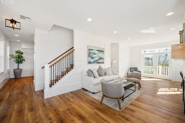 living room with recessed lighting, wood finished floors, visible vents, and stairs