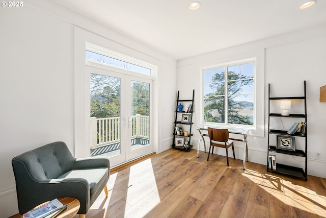 living area with recessed lighting, light wood-style flooring, and french doors