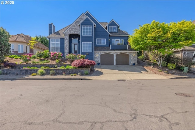 view of front of house with an attached garage, driveway, and stone siding