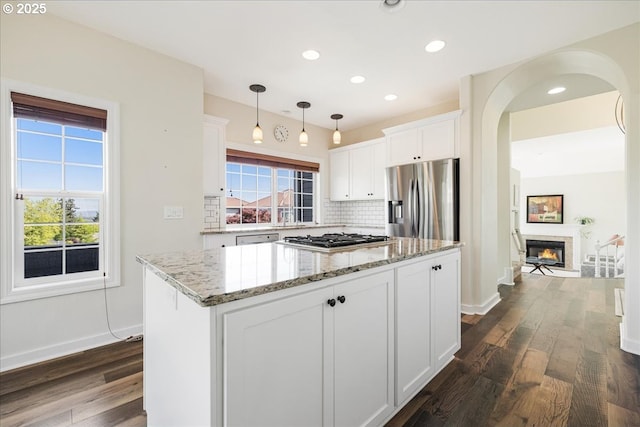 kitchen featuring white cabinetry, tasteful backsplash, a healthy amount of sunlight, and stainless steel appliances