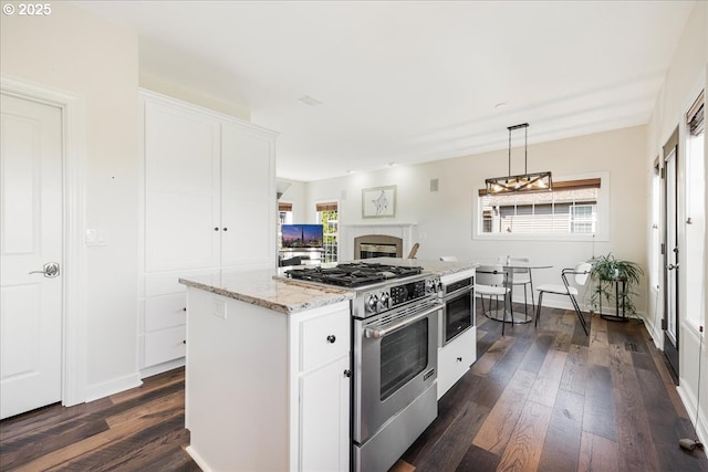 kitchen featuring high end range, dark wood-style floors, and a healthy amount of sunlight