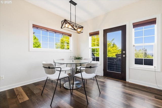 dining area featuring dark wood-type flooring, baseboards, and visible vents
