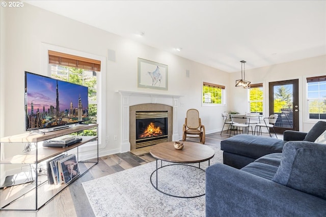 living area with baseboards, wood finished floors, and a tile fireplace