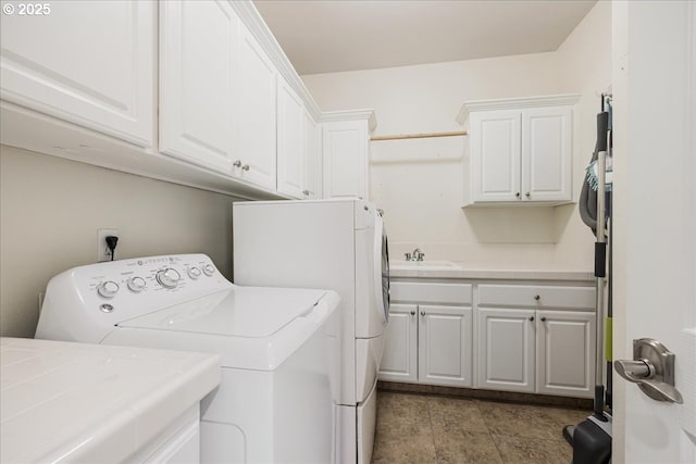 washroom featuring a sink, cabinet space, and washing machine and clothes dryer