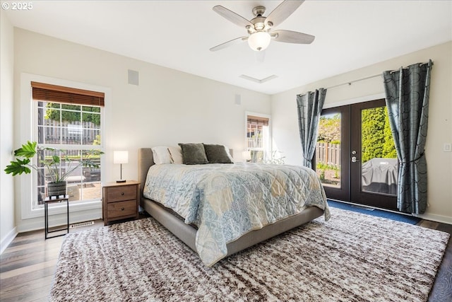 bedroom with french doors, wood finished floors, multiple windows, and access to exterior