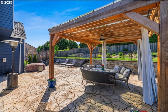 view of patio featuring a hot tub, outdoor lounge area, a ceiling fan, and a fenced backyard