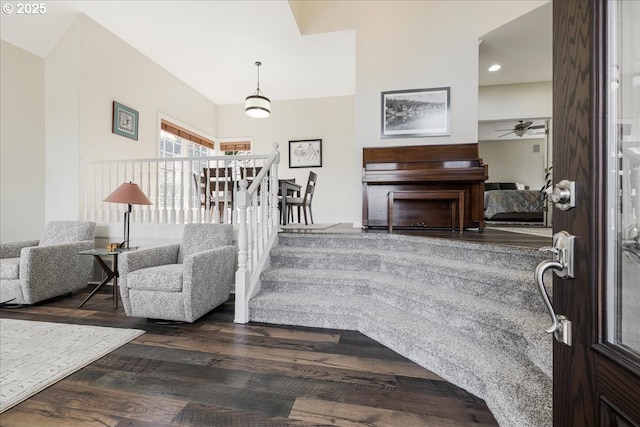 entrance foyer featuring dark wood-style flooring, a ceiling fan, and stairway