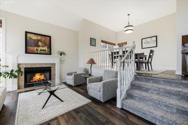 living area with baseboards, a fireplace, and dark wood-style flooring