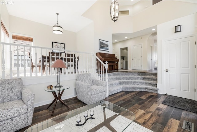 interior space with stairs, arched walkways, dark wood finished floors, and visible vents
