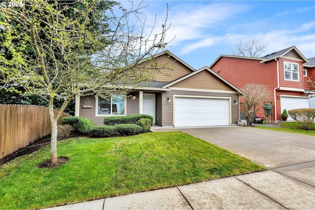 view of front facade with a front yard, concrete driveway, an attached garage, and fence