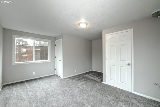 unfurnished bedroom featuring a textured ceiling, carpet, and baseboards