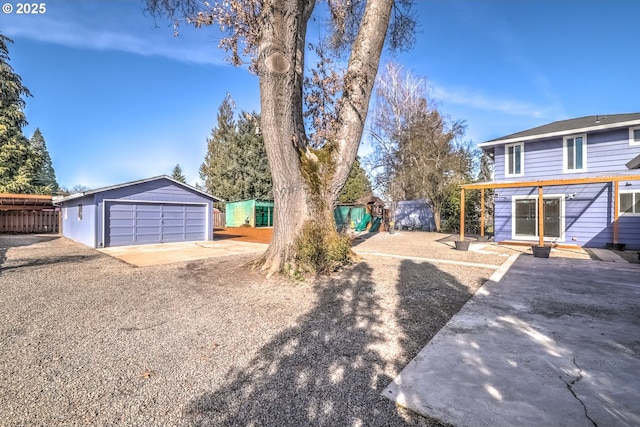 view of front of property with a garage, an outdoor structure, and fence