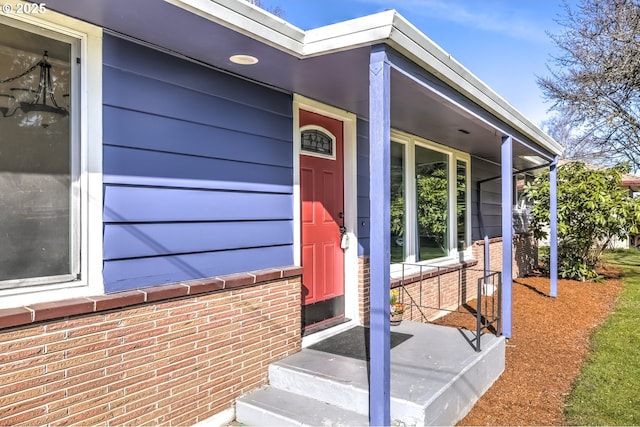 doorway to property featuring brick siding