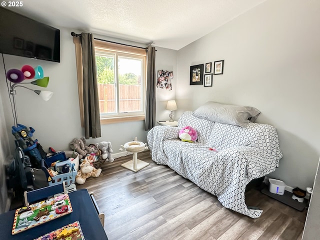 1315 Auburn Ave, Baker City, OR 97814 - bedroom featuring wood finished floors, lofted ceiling, a textured ceiling, and baseboards