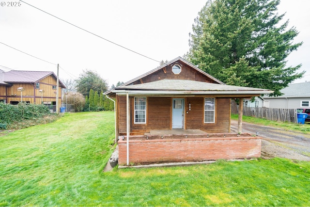 bungalow featuring a front yard, a porch, and fence