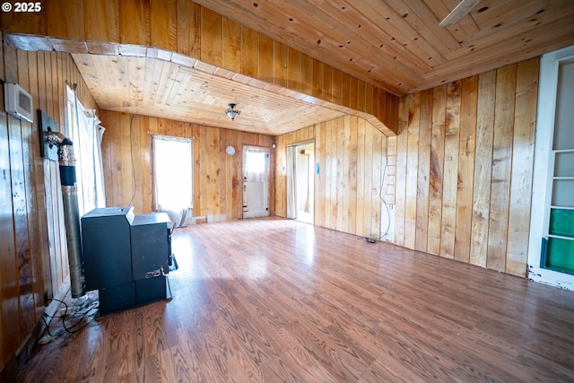 unfurnished living room with wood finished floors, wooden walls, and wood ceiling