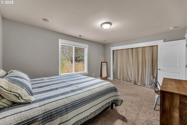 bedroom featuring a textured ceiling, carpet flooring, and visible vents