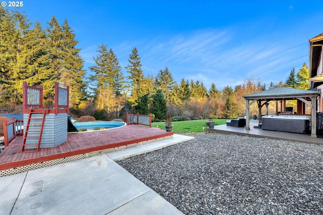 view of yard featuring a wooden deck, a hot tub, and a gazebo