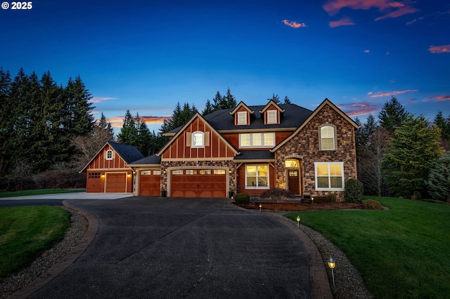 view of front of home featuring driveway, a garage, a lawn, stone siding, and board and batten siding