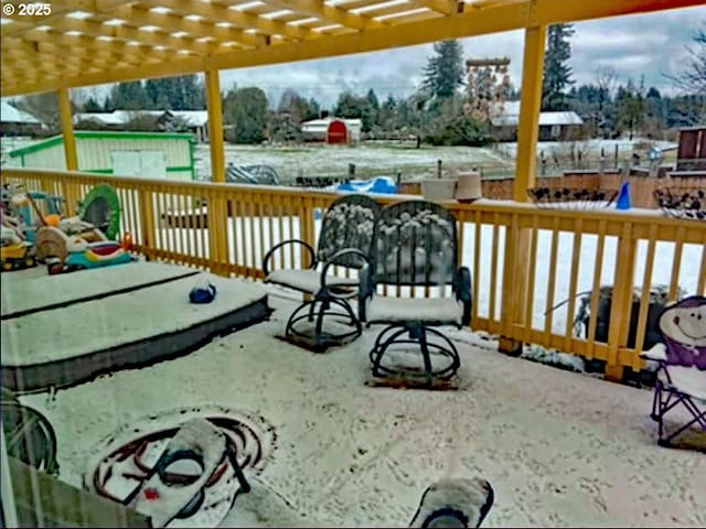 snow covered deck with a pergola