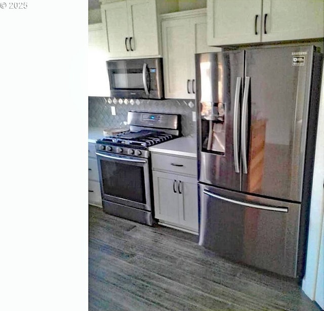 kitchen featuring white cabinets, dark hardwood / wood-style floors, appliances with stainless steel finishes, and tasteful backsplash