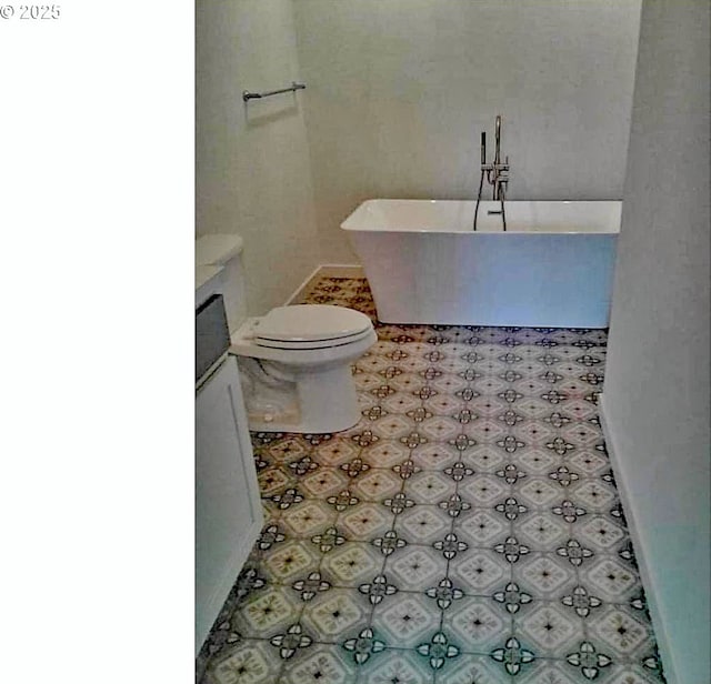 bathroom featuring a washtub, toilet, and vanity