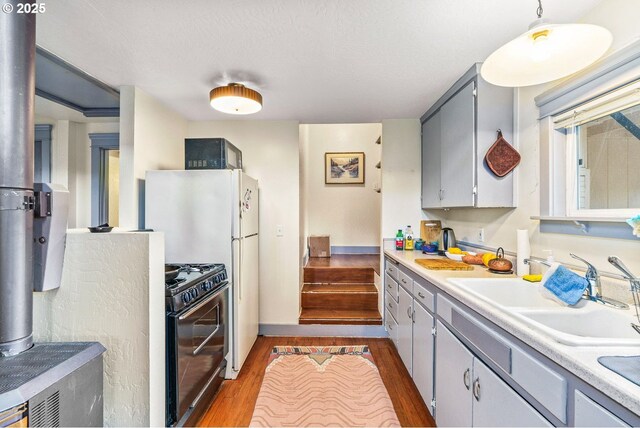 kitchen featuring a sink, light countertops, black appliances, and dark wood finished floors