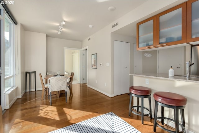 dining space with hardwood / wood-style floors, a wealth of natural light, and track lighting