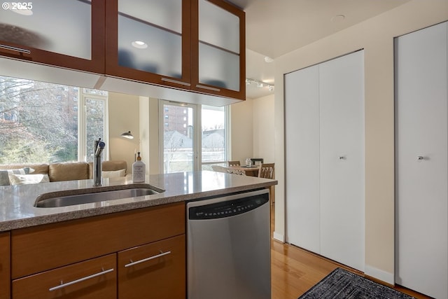 kitchen featuring light stone counters, sink, a wealth of natural light, and dishwasher