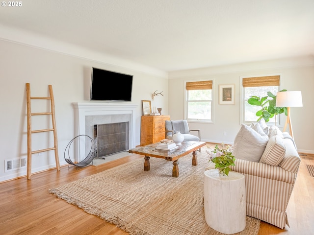 3556 NE Alberta Ct, Portland, OR 97211 - living room with a tiled fireplace, wood finished floors, and baseboards