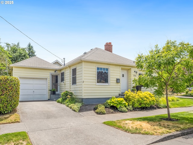 3556 NE Alberta Ct, Portland, OR 97211 - view of front facade featuring driveway, a chimney, and a garage