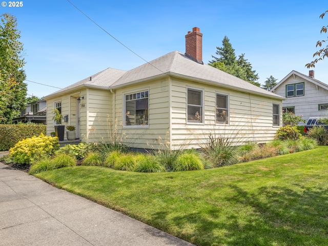 3556 NE Alberta Ct, Portland, OR 97211 - view of side of home featuring a lawn and a chimney