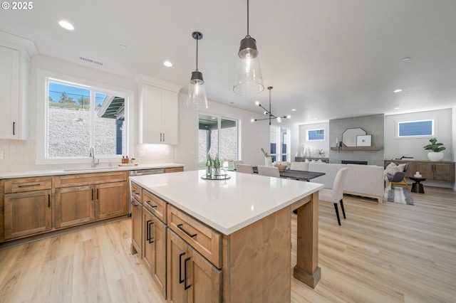 143 W 20th Way, La Center, WA 98629 - kitchen featuring light wood finished floors, open floor plan, light countertops, brown cabinets, and recessed lighting