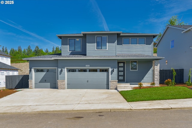 143 W 20th Way, La Center, WA 98629 - prairie-style house with concrete driveway, stone siding, and a garage