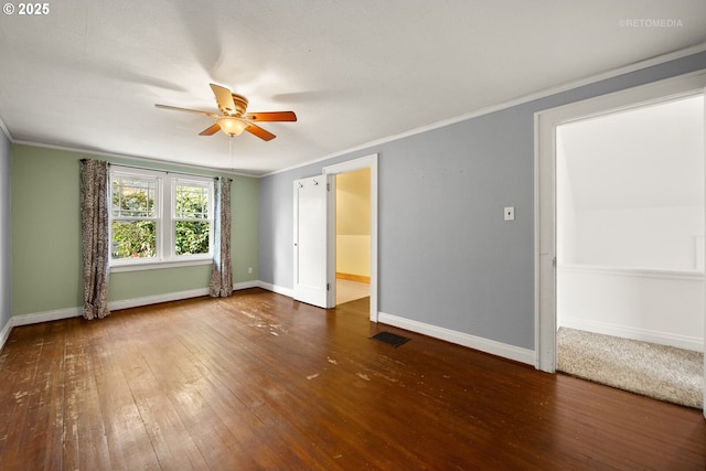 empty room featuring crown molding, dark wood-type flooring, and ceiling fan