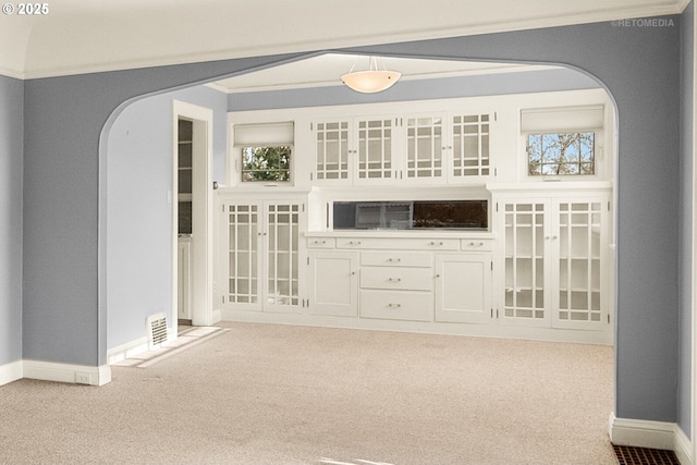 carpeted spare room with ornamental molding and plenty of natural light