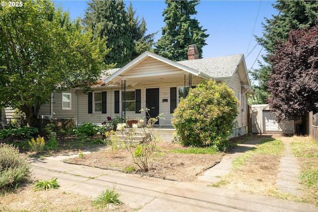 9465 N Midway Ave, Portland, OR 97203 - view of front of home featuring a porch, a chimney, driveway, and an outbuilding