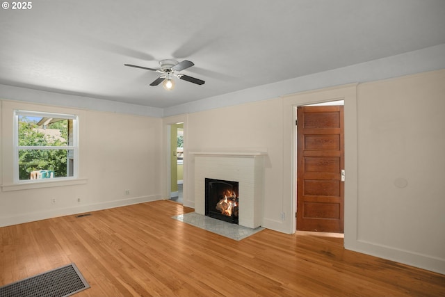 9465 N Midway Ave, Portland, OR 97203 - unfurnished living room with a brick fireplace, light wood-type flooring, and ceiling fan