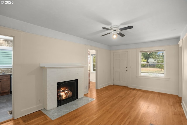 9465 N Midway Ave, Portland, OR 97203 - unfurnished living room with ceiling fan, a brick fireplace, and light wood-style floors