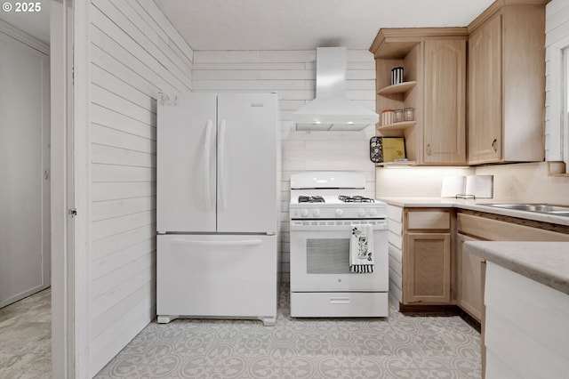 kitchen featuring white appliances, wall chimney range hood, open shelves, light countertops, and a sink