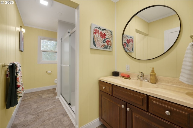 full bathroom featuring crown molding, vanity, a stall shower, toilet, and baseboards